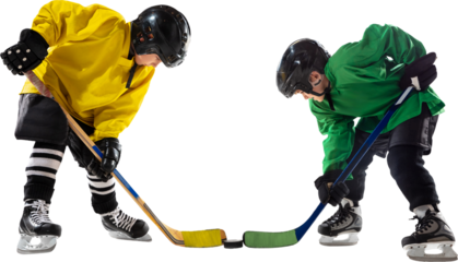 Two young hockey players, boys one in yellow and green uniform, face off with sticks hover near puck, ready for action isolated on transparent background. Concept of sport, childhood, active lifestyle