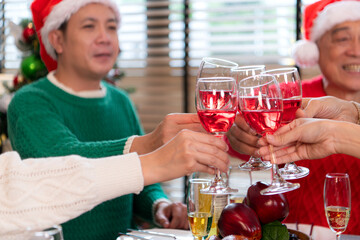 Family members are toasting with wine and drinks while sharing a meal together during the Christmas celebration at home