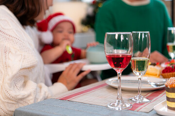 Family members are toasting with wine and drinks while sharing a meal together during the Christmas...