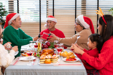Family members are exchanging gifts with each other in the dinner time during the Christmas holiday...