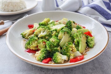 Homemade Stir fried broccoli  in cream ceramic plate on grey cement  table background,Vegetarian food