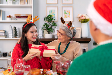 Family members are exchanging gifts with each other in the dinner time during the Christmas holiday...
