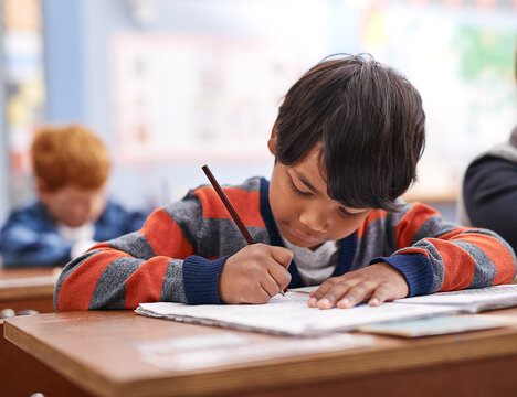 Pencil, writing and boy in classroom for lesson in growth, child development and notebook for education. Problem solving, learning and students with exam notes, math and study at elementary school
