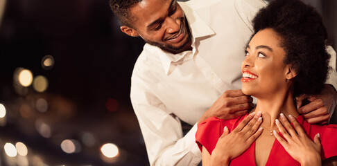 Happy African American Man Putting Necklace On Girlfriend Dating Having Valentine Dinner In...
