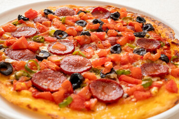 homamade pizza with salami and tomatoes