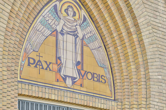 Angel mosaic art on church facade with "Pax Vobis" text