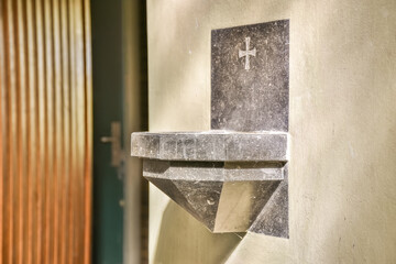 Marble holy water font with cross design in church