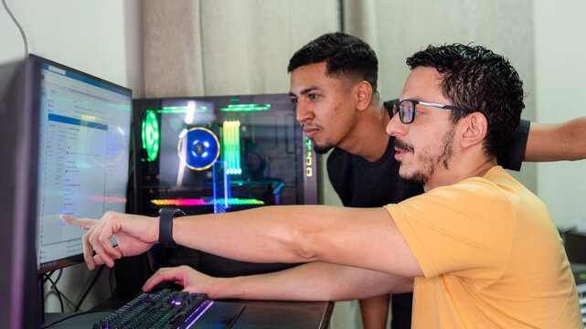 Gay couple collaborating at a computer in a tech setup