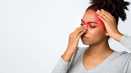 Exhausted afro woman rubbing nose and head, suffering from sinusitis, grey background, copy space