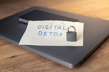Simple note for digital detox placed on a wooden table with a locked phone nearby