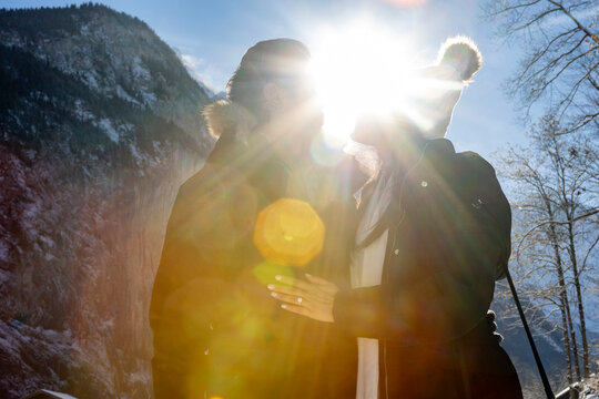 Anonymous couple celebrating engagement in snowy mountain setting