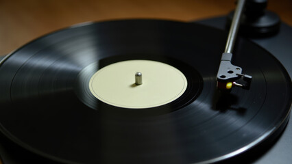 Black Vinyl Record Spinning on a Wooden Turntable with Retro Tonearm