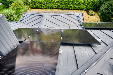 House with solar panels on rooftop for generating electricity through photovoltaic effect. Home...