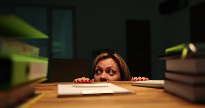 Woman crawls out from under table in office and is afraid of thunderstorms and bad weather. Astrapophobia and fear of thunder and lightning