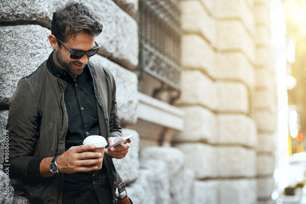 Poster man, outdoor and happy with smartphone on wall with coffee in city for social media post and interac