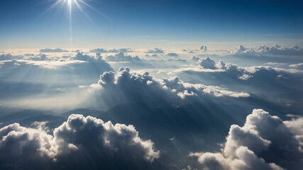 Sun rays shining through clouds in a vivid blue sky during a serene and breathtaking aerial view above clouds.