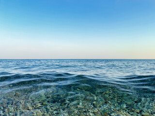 Calm sea under a blue sky at sunrise. calm colors. waterline. waves. ripples. sea water surface. 