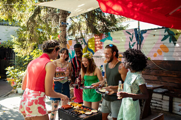 Diverse group of friends enjoying barbecue hostel party outdoors