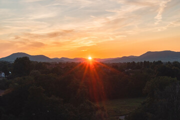 Sun Setting Behing the Mountain Horizon Casting an Orange Sunshine