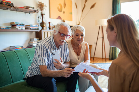 Worried senior couple talking to financial advisor at home