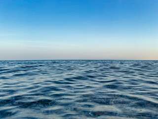 Calm sea under a blue sky at sunrise. calm colors. waterline. waves. ripples. sea water surface. 