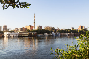 Cairo, Egypt - 8 February 2022: houseboats and a mosque on the Nile in Zamalek district in golden hour