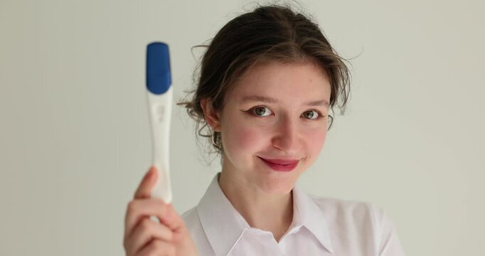 Young happy woman holding pregnancy tests. Negative pregnancy test