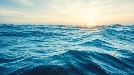Obraz premium Serene ocean waves gently rippling under a golden sunset sky, creating a peaceful and calming seascape scene.