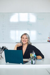 Photo of a pretty young woman working at a school. Online foreign language teacher