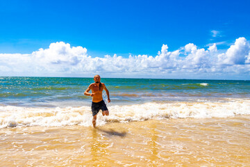 Male tourist man with long hair on Caribbean beach Mexico.