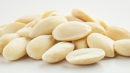 A close-up of a handful of blanched almonds on a white background, highlighting their smooth surface and pale color in a clean, minimalist setting.