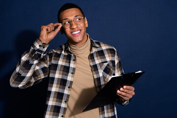 Photo of funky dreamy guy dressed plaid shirt signing contract looking emtpy space isolated blue color background