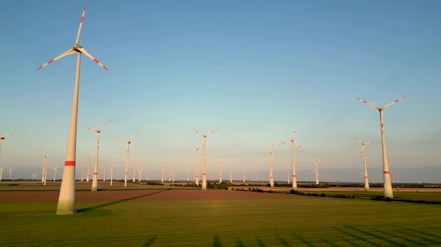 Aerial, sich drehende Windr&auml;der eines grossen Windparks im Abendlicht. Landschaft in Norddeutschland mit gro&szlig;en Windr&auml;dern die Energy in nachhaltiger Form erzeugen