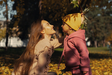 happy mother and her little daughter at autumn outdoors