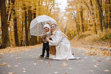 Fototapeta premium Mother and her daughter playing and having fun in autumn forest