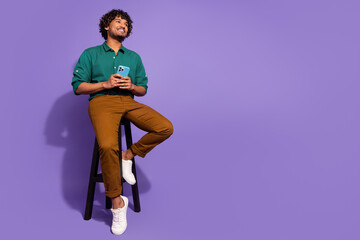 Full body length photo of handsome mexican guy sitting stool with smartphone minded looking novelty...