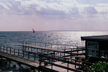 Seascape with sailing boat in the distance and pier