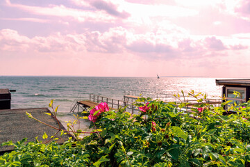Beautiful seascape with sailing boat in the distance and pier