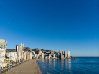 Aerial photo taken in Benidorm in Spain Alicante, showing the beautiful beach of Playa Levante, hotels, buildings, and high rise skyline cityscape with people relaxing on the beautiful beach