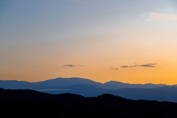 Silhouettes of mountains in various planes at sunset