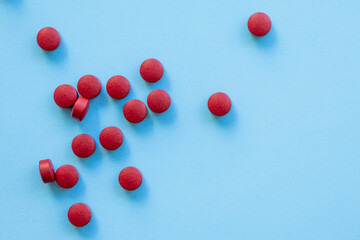 a scattering of red round tablets on a bright blue background