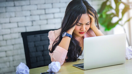 Young Asian woman stress with her frustrated or unsuccessful business online shopping at office. Boring or unhappy business office life concept.