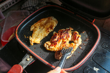 Close up of a pan with chicken frying inside. The chicken is golden brown and crispy. Chicken breast and thigh cooking in a hot pan Getting crispy and delicious.