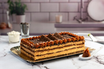 sweet dessert choco cake with chocolate cookies dulce de leche cream cheese on kitchen counter decorated with broken chocolate