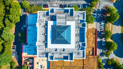 Aerial View of Symmetrical Building with Pyramid Glass Roof and Parking Lot