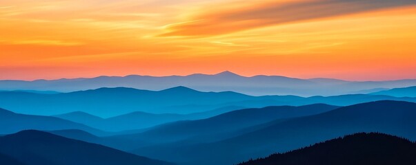 Obraz premium Sunset over layered mountain range with vibrant
