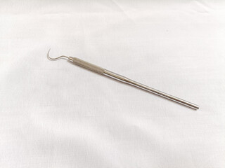 A slender stainless dental instrument 