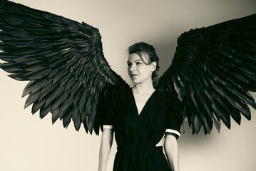 Woman with majestic black wings in dramatic monochrome portrait