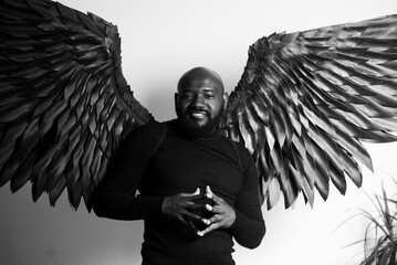 Black and white portrait of man with large angelic wings