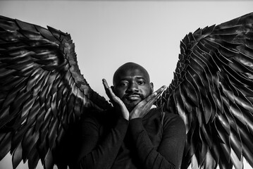 Portrait of a man with angelic wings in black and white